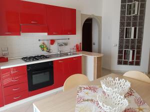 a kitchen with red cabinets and a dining table at Casa Laura in Acciaroli