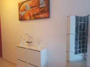 a room with a refrigerator and a painting on the wall at Casa Laura in Acciaroli +32 photos