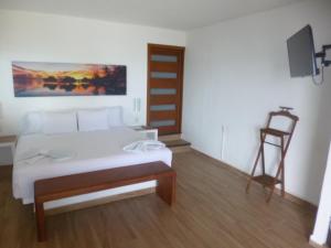 um quarto com uma cama e uma cadeira em Villa Marilu B&B em Bacalar
