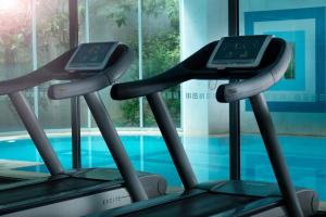two treadmill machines in front of a swimming pool at Holiday Inn Athens Attica Av, Airport W., an IHG Hotel in Athens