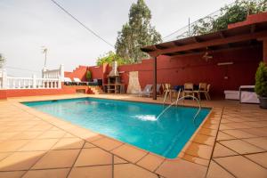 a swimming pool on a patio next to a house at Mountain Chalet Sea Views & Pool in Moya