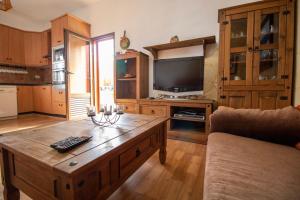 sala de estar con mesa de centro y TV en Mountain Chalet Sea Views & Pool, en Moya