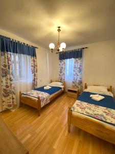 una camera con due letti e un lampadario a braccio di Viktor Rooms a Kotor (Cattaro)