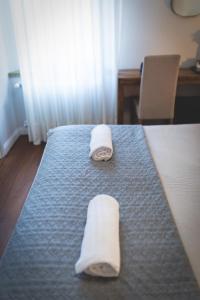 two towels on a bed in a hotel room at Piazza Duomo Deluxe in Cecina