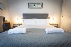 a bedroom with a large bed with two white pillows at Piazza Duomo Deluxe in Cecina