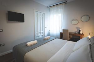 a bedroom with a bed with two towels on it at Piazza Duomo Deluxe in Cecina