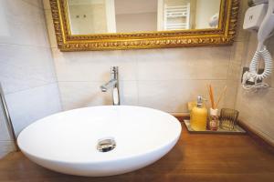 a white sink in a bathroom with a mirror at Piazza Duomo Deluxe in Cecina