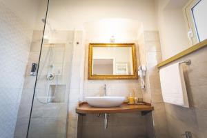 a bathroom with a sink and a shower with a mirror at Piazza Duomo Deluxe in Cecina
