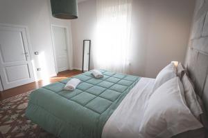 a bedroom with a large green bed in a room at Piazza Duomo Deluxe in Cecina