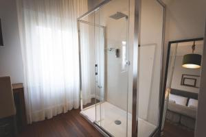 a glass shower in a room with a window at Piazza Duomo Deluxe in Cecina