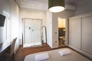 a white room with a bed and a bathroom at Piazza Duomo Deluxe in Cecina