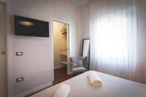 a bedroom with a bed and a television on a wall at Piazza Duomo Deluxe in Cecina
