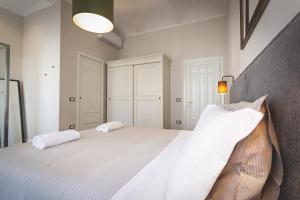 a bedroom with a large white bed with two pillows at Piazza Duomo Deluxe in Cecina