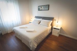 a bedroom with a bed with two towels on it at Piazza Duomo Deluxe in Cecina