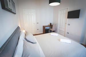 a bedroom with a large white bed with two pillows at Piazza Duomo Deluxe in Cecina