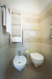 a bathroom with a white toilet and a sink at Piazza Duomo Deluxe in Cecina