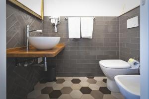 a bathroom with a sink and a toilet at Piazza Duomo Deluxe in Cecina