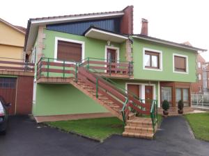 una casa verde con una escalera delante de ella en Casa Con Jardin, en Pomaluengo