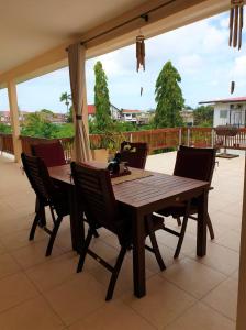 a wooden table and chairs on a patio at Amalia Apartments in Paramaribo