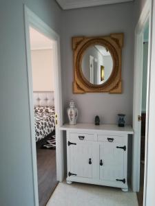 1 dormitorio con espejo y tocador blanco en Casa Con Jardin, en Pomaluengo