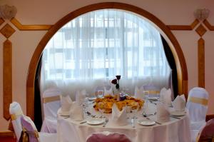 a table with a white table cloth and a large window at Copthorne Downtown by Millennium in Abu Dhabi