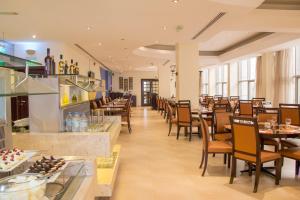 a restaurant with tables and chairs and a bar at Copthorne Downtown by Millennium in Abu Dhabi