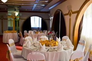 a dining room with white tables and white chairs at Copthorne Downtown by Millennium in Abu Dhabi