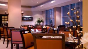 a restaurant with tables and chairs in a room at Copthorne Downtown by Millennium in Abu Dhabi