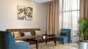 a living room with a couch and two chairs at Copthorne Downtown by Millennium in Abu Dhabi