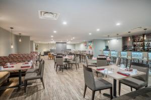 a dining room with tables and chairs and a restaurant at Holiday Inn Atlanta/Roswell by IHG in Roswell