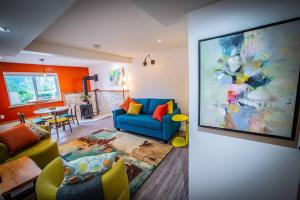 a living room with a blue couch and a painting at eARTh studios GallerySuite in Nelson