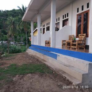 a house with chairs on the front of it at Ramdan Homestay in Kuta Lombok