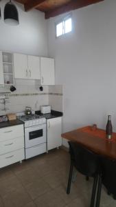 a kitchen with a stove and a wooden table at Departamento Ananda in General Roca