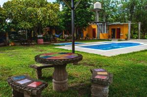 a garden with a table and a fountain in the grass at Hostal Nathaly in Moyogalpa