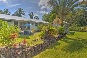 a house with a garden and a stone wall at Hale O Nani Mala Pua home in Pahoa