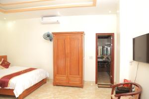 a bedroom with a bed and a wooden cabinet at Mai Anh Hotel in Lao Cai