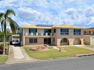 a large house with a palm tree in front of it at Holiday on Hillcrest in Scarness