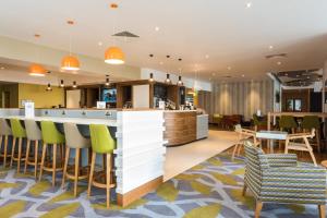 a hotel lobby with a bar and chairs at Holiday Inn Brighton Seafront by IHG in Brighton & Hove