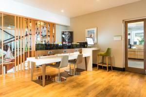 a room with a table and chairs and a staircase at Holiday Inn Brighton Seafront by IHG in Brighton & Hove