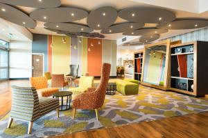 a lobby with chairs and tables in a store at Holiday Inn Brighton Seafront, an IHG Hotel in Brighton & Hove