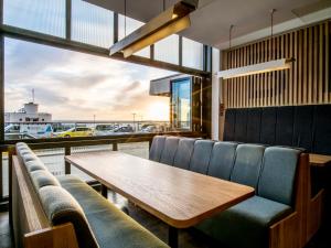 a dining room with a table and chairs and a window at Holiday Inn Brighton Seafront by IHG in Brighton & Hove
