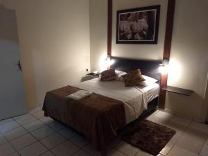 1 dormitorio con 1 cama con 2 lámparas en HOTEL CARMO PALACE, en Carmo do Paranaíba