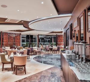 a restaurant with tables and chairs and windows at Holiday Inn Bucaramanga Cacique by IHG in Bucaramanga