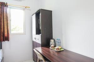 uma secretária de madeira num quarto com uma janela em PAS Residence em Paniki