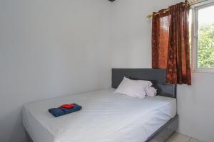 1 cama blanca con 2 almohadas y ventana en PAS Residence en Paniki