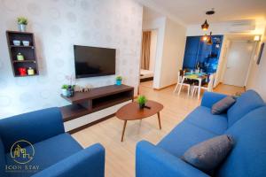 sala de estar con sofá azul y TV en The Wave Residence Melaka, en Melaka