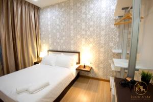 - une chambre avec un lit doté d'un couvre-lit blanc et d'une fenêtre dans l'établissement The Wave Residence Melaka, à Malacca