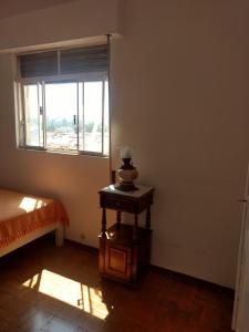 um quarto com uma cama, uma janela e uma mesa em Apart 603 - Centro Histórico em Itu
