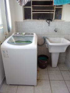 uma pequena casa de banho com uma máquina de lavar roupa e um lavatório em Apart 603 - Centro Histórico em Itu