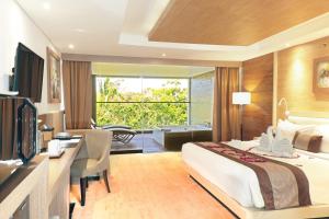 Postel nebo postele na pokoji v ubytování de Vins Sky Hotel Seminyak